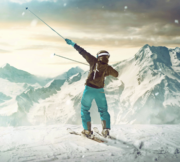Skifahrer im Schnee mit dynamischer Siegerpose